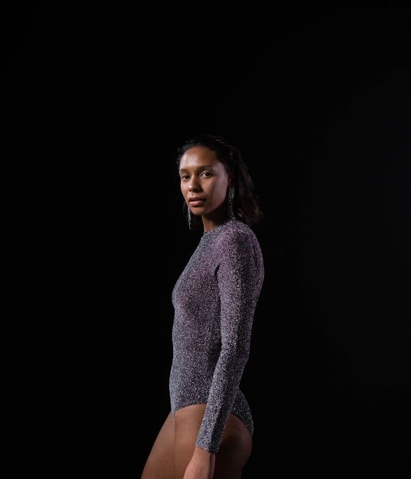 Woman in a calm yoga pose in a modern studio with soft lighting.
